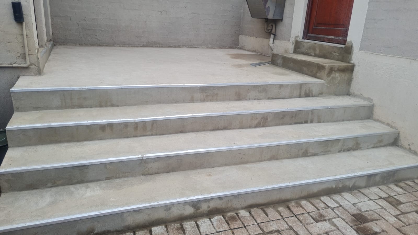 Concrete steps with metal edging leading to a doorway